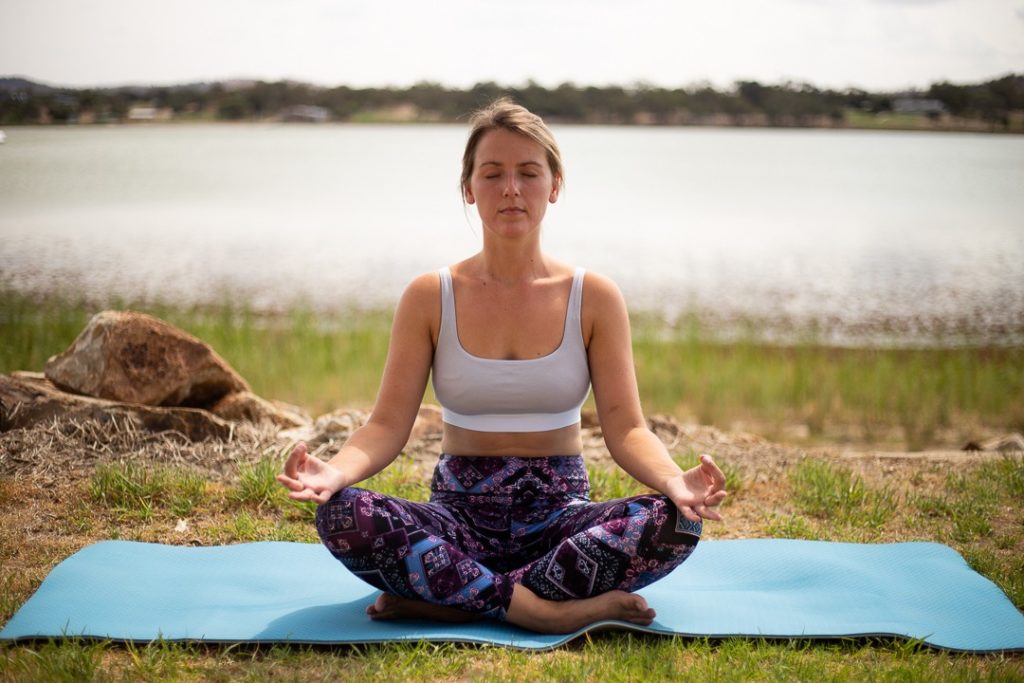 girl sitting on yoga mat, meditating